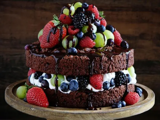 шоколадний торт із вершковим сиром прикрашений ягодами та шоколадною глазур'ю